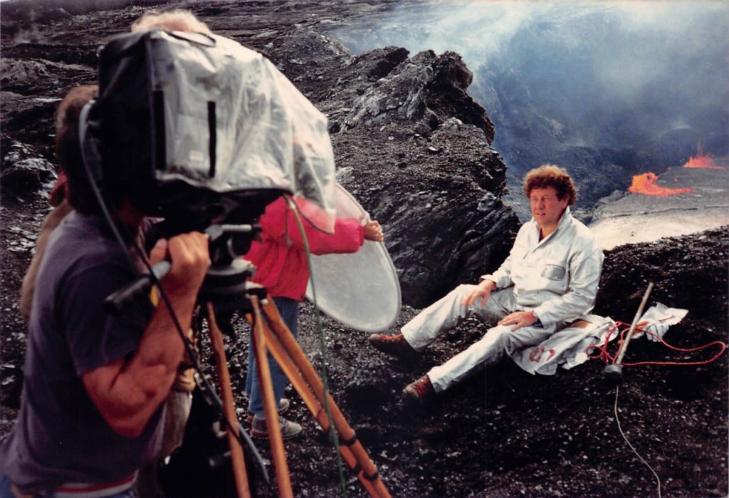 Hawai'i filmmaker, Mike May, shot this photo of Fire of Love's Maurice Kraft on Kilauea in 1988. In this photo, Maurice sits on the edge of a volcano in his silver suit. 